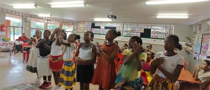 南非學(xué)生展示民族服飾，合唱《聽我說謝謝你》。
