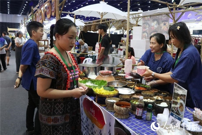 游客在攤位前購買特色美食。朱瀟逸攝