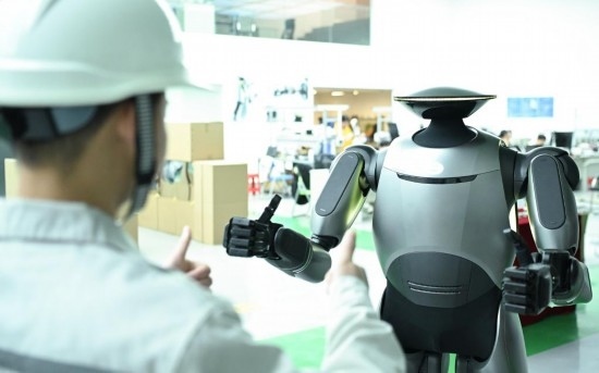 在廣汽研究院，人形機器人團隊的周仁義在演示GoMate機器人互動功能（新華社記者 鄧華 攝）