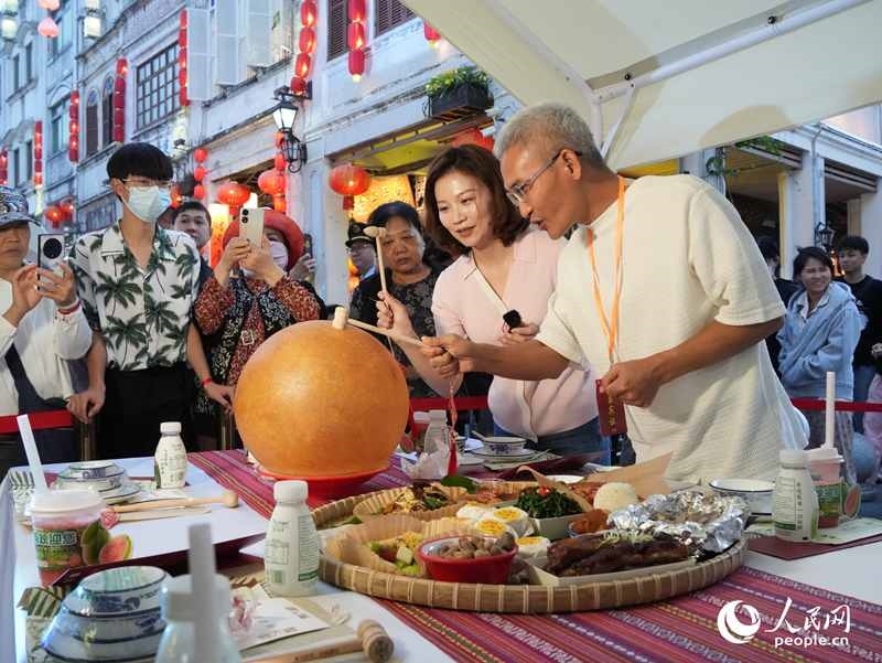 嘉賓品嘗海南傳統(tǒng)美食“煎堆”。人民網(wǎng)記者 張力洋攝