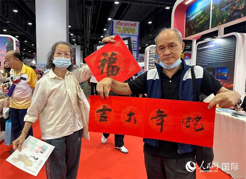2025蛇年春節(jié)，泰國市民展示他們領(lǐng)到的華人手寫春聯(lián)。人民網(wǎng)記者 簡(jiǎn)承淵攝