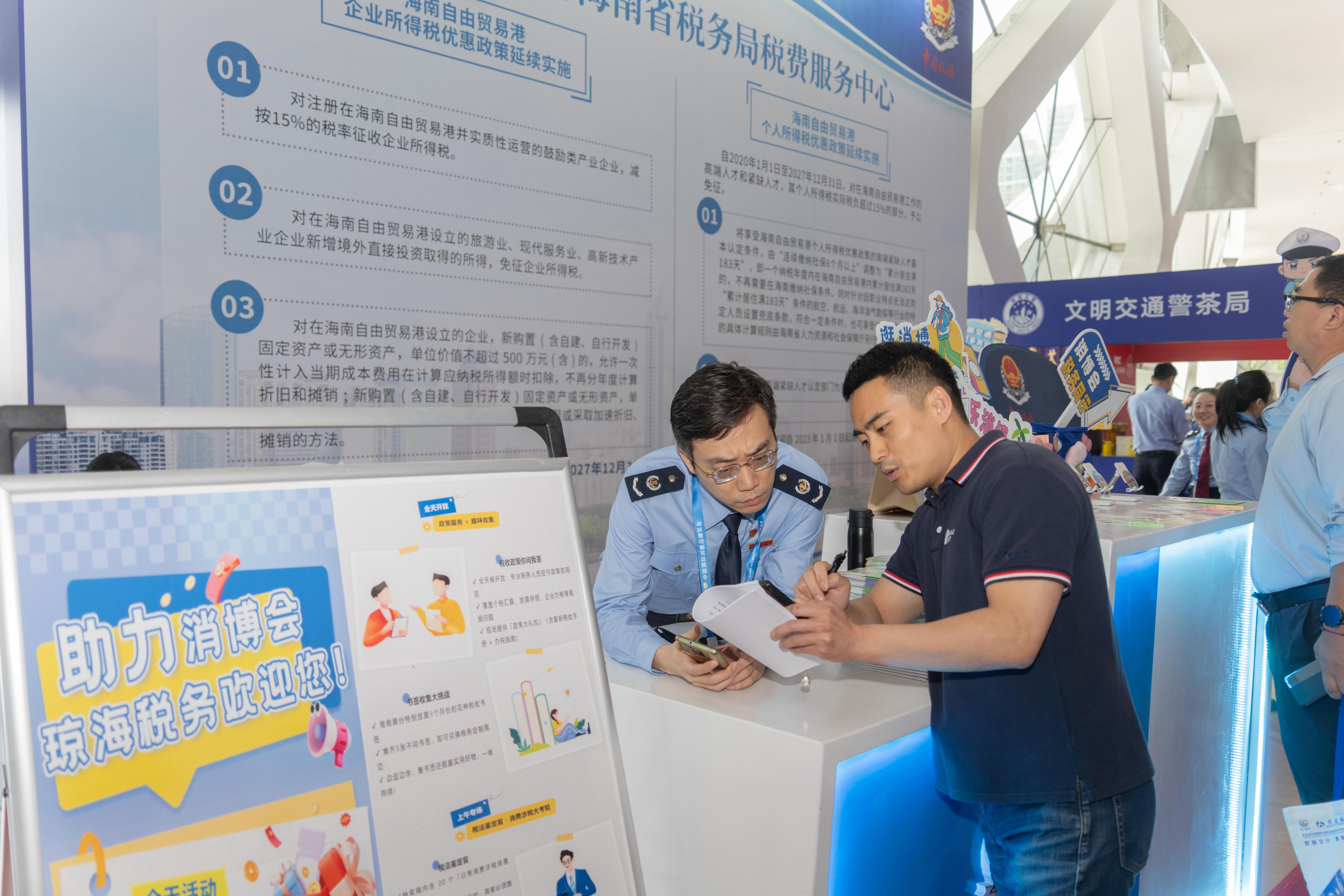 稅務服務臺工作人員向記者介紹服務參展外商的具體舉措。人民網(wǎng)記者 許崢攝
