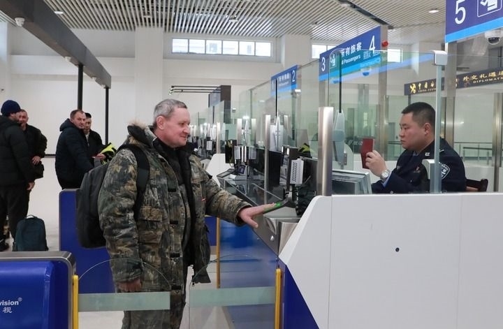 2024年12月10日，在黑河公路口岸旅檢大廳，黑河出入境邊防檢查站民警為首班次客車入境旅客辦理邊檢通關(guān)手續(xù)。當(dāng)日，中國黑河公路口岸—俄羅斯卡尼庫爾干公路口岸旅客運輸正式開通。新華社發(fā)（劉松攝）