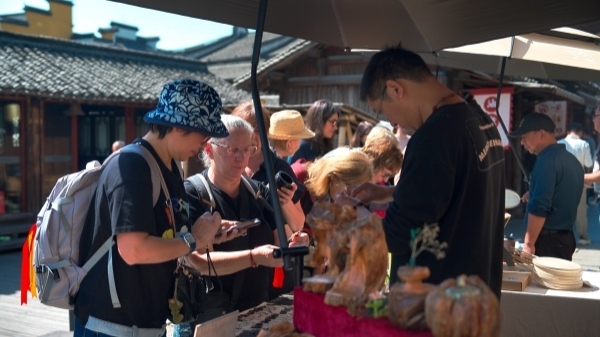 “五一”期間，游客正在烏鎮(zhèn)“水鄉(xiāng)碼頭”挑選購買文創(chuàng)產(chǎn)品。受訪者供圖