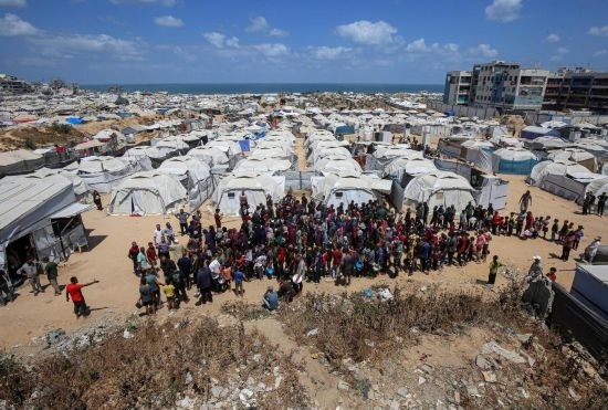 5月28日，人們在加沙城西部的沙提難民營等待領(lǐng)取救助食物。新華社發(fā)（里澤克·阿卜杜勒賈瓦德攝）