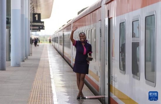 5月31日，在蒙內(nèi)鐵路內(nèi)羅畢站，一名乘務員在即將開往蒙巴薩的E2次列車旁等候乘客。新華社記者 李亞輝 攝