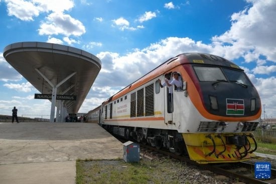 5月31日，在蒙內(nèi)鐵路內(nèi)羅畢站，機車駕駛員蔣立平（右）和博爾在即將開往蒙巴薩的E2次列車上揮手致意。新華社記者 楊光 攝