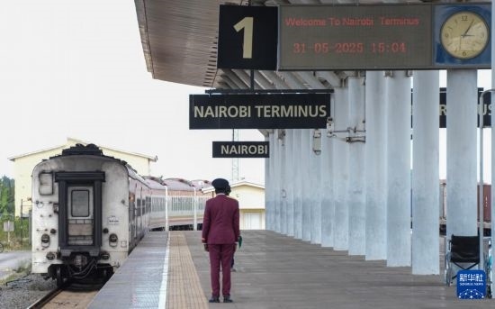 5月31日，在蒙內(nèi)鐵路內(nèi)羅畢站，工作人員目送開往蒙巴薩的E2次列車駛離站臺。新華社記者 李亞輝 攝